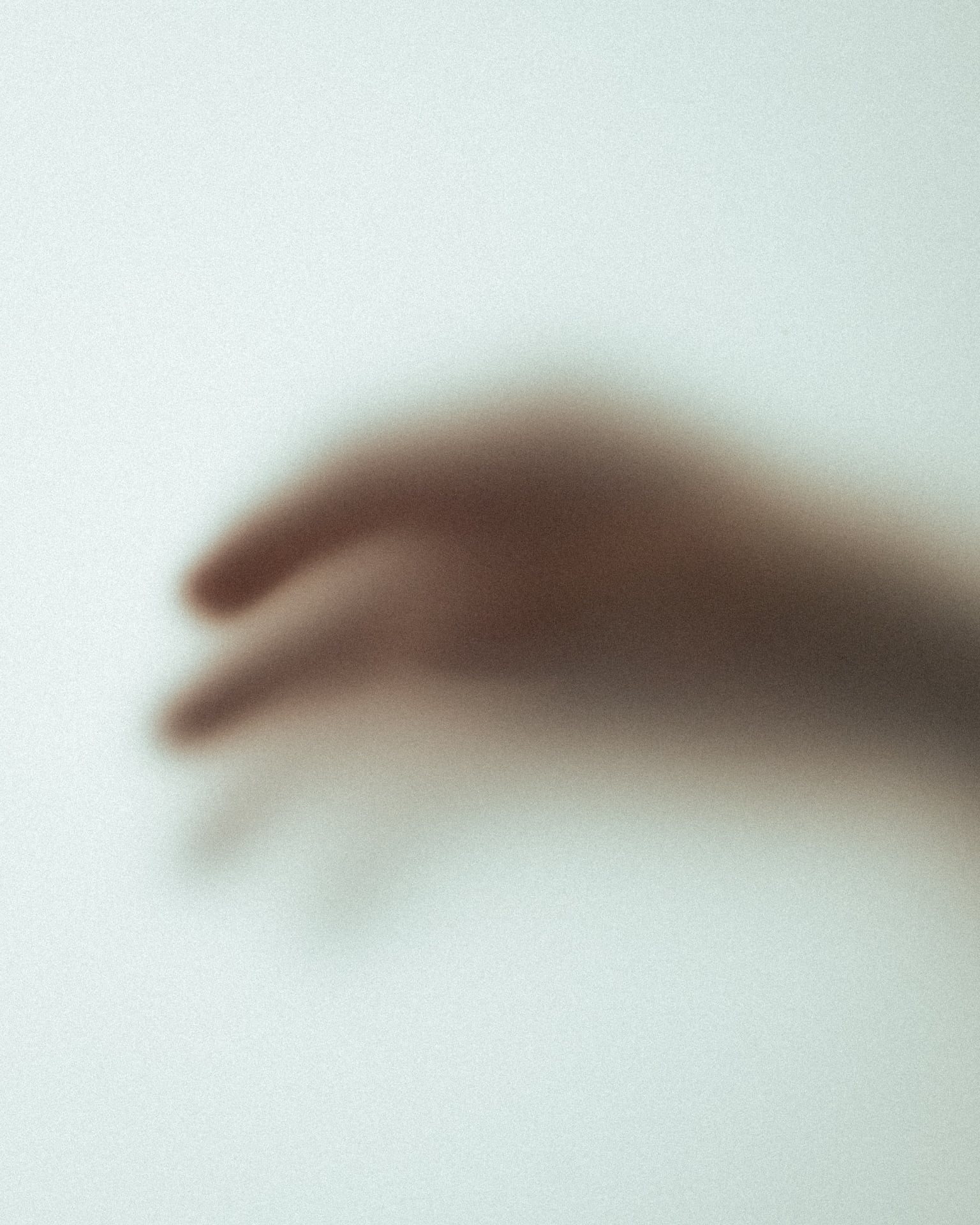 A hand behind frosted glass, from the Tero film